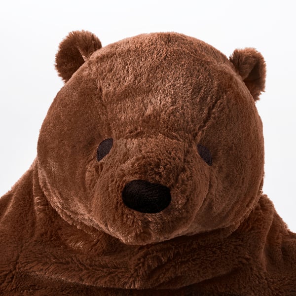 Soft teddy bear with brown fur, black eyes, and nose, posed with open arms, inviting a comforting hug.