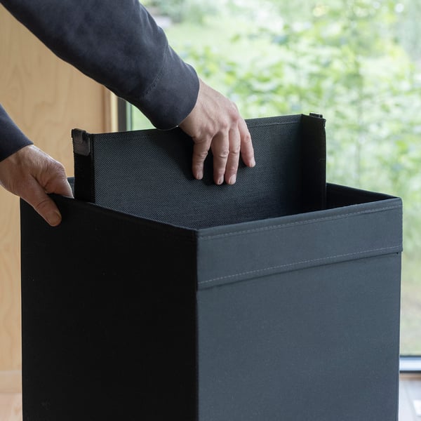 Person placing adjustable divider in a DRÖNA storage box.