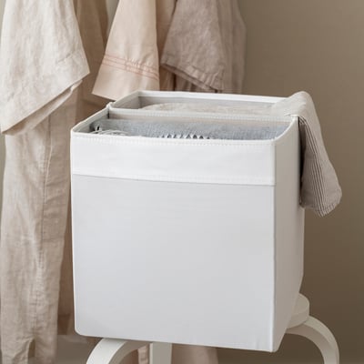 White storage bin with removable divider, organising items into two compartments. Fits inside DRÖNA box.