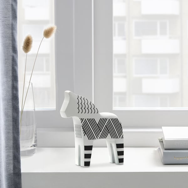 Black and white striped horse figurine, DVÄRGSLINKE, sits near a vase on a windowsill, standing taller than a small book. Crafted from solid pine.