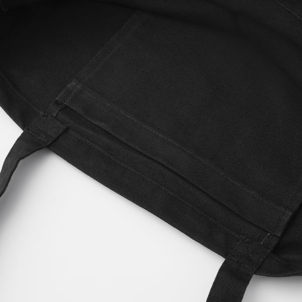 Black fabric bag close-up, showcasing sturdy cotton material and well-stitched seams, ideal for everyday use.