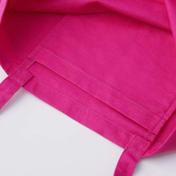 Bright pink fabric bag with sturdy handles, detailed stitching; high-quality cotton material.