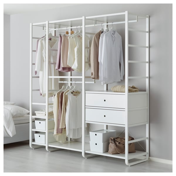 A modern wardrobe system with shelves, hangers, and drawers for efficient clothing storage, positioned against a wall in a bedroom setting.