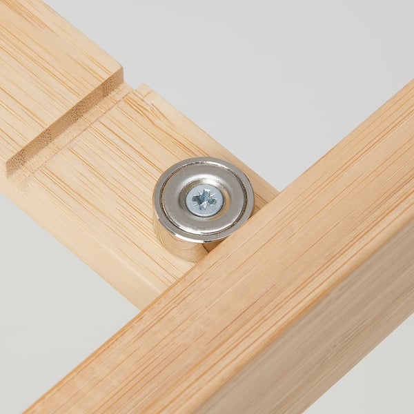Wooden laptop stand bolt detail. Close-up of a cylindrical chrome bolt securing wooden planks.