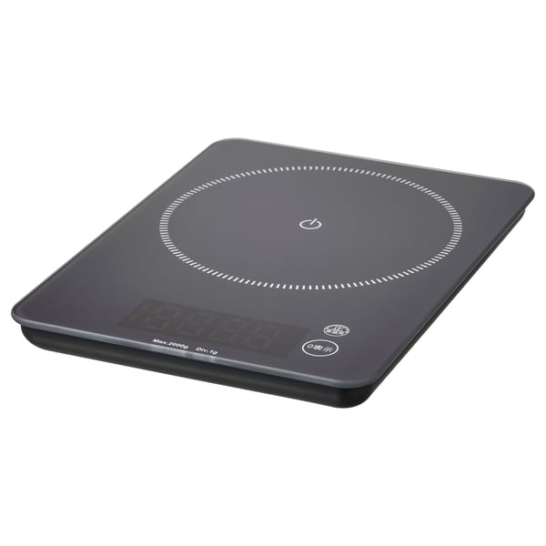 Black rectangular GENOMSNITT scale with glass top, plastic base, and rubber feet. Digital display, minimalist design.
