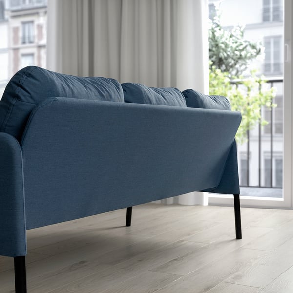 Modern navy blue sofa, small & sleek, great for tight spaces. Dark wood floor & city view.