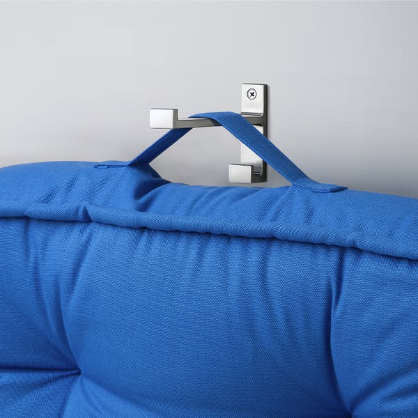 Blue fabric-covered cushion hangs from wall hook by handle.
