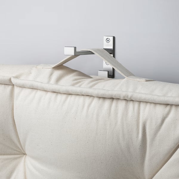 Beige floor cushion on wall hook. Handles visible for easy carrying.
