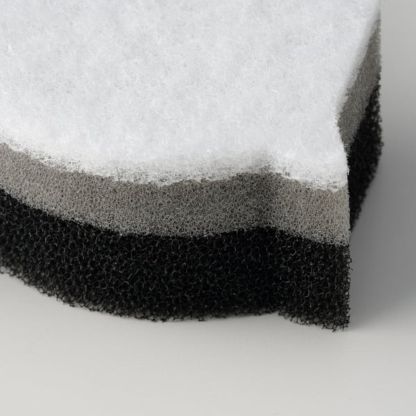 Black and white sponge with soft and coarse sides on a plain light surface