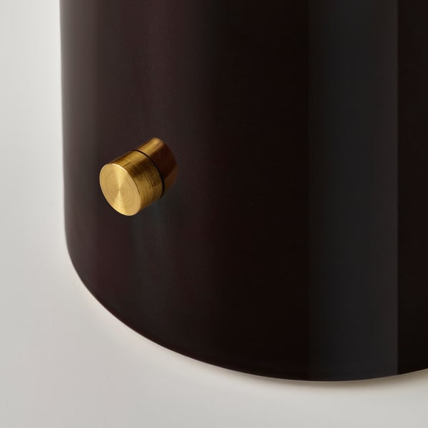 Cylindrical black lamp with textured gold knob for dimming light, reflecting high-quality design and craftsmanship.