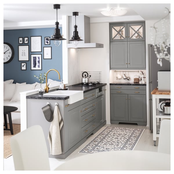 Modern kitchen with grey cabinets, white HAVSEN sink, brass tap, and hanging lamps.