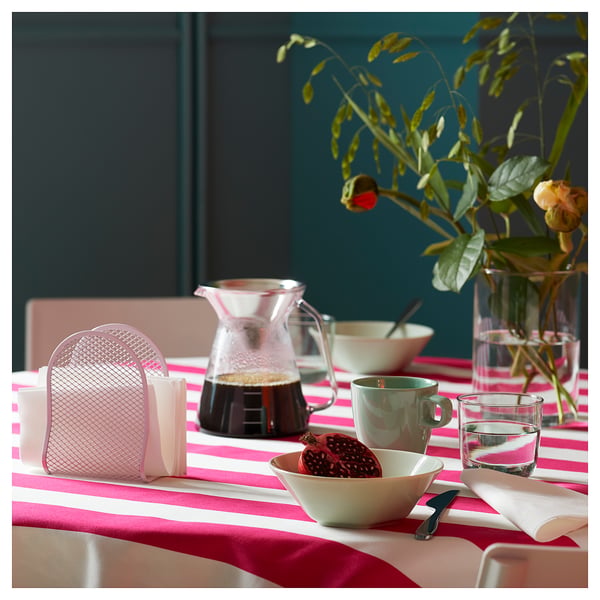 Bright table with HÖGMODIG coffee maker, mugs, napkins, tablecloth, fruit, and flowers.
