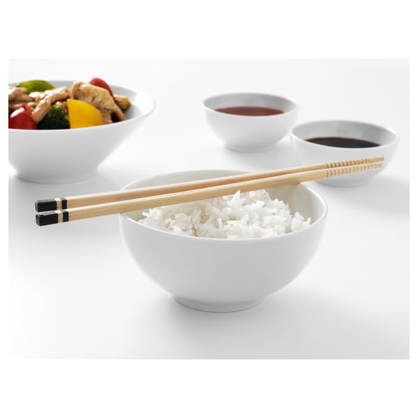 Three white bowls: one with rice and chopsticks, another with sauce, and a third with stir fry. Ideal for asian cuisine.
