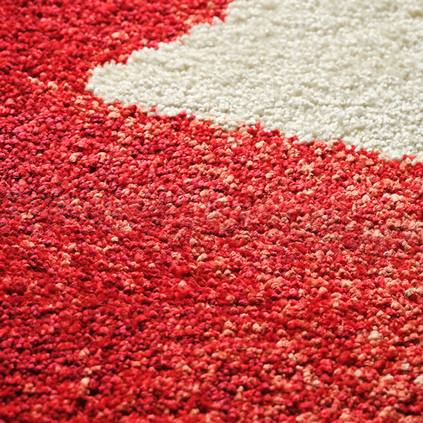 Vibrant red and off-white rug close-up, soft texture, high quality.