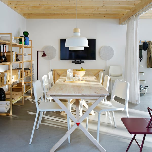 White IKEA PS 2026 folding table with chairs in modern room.