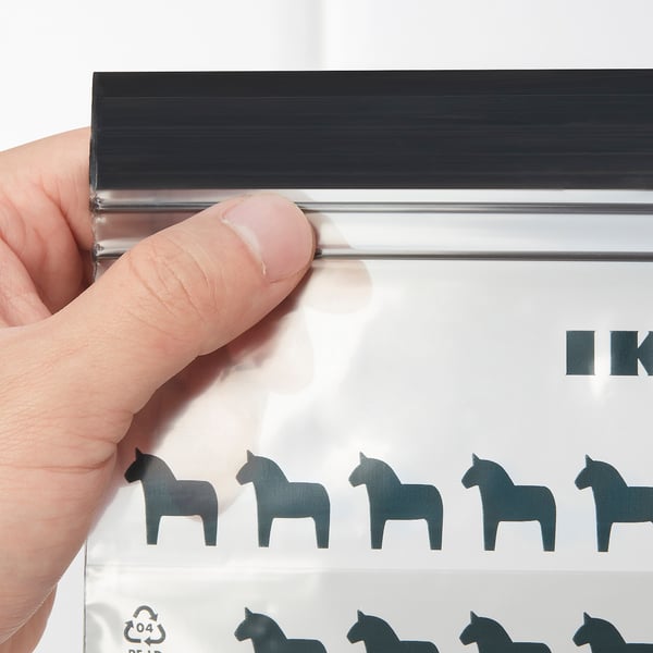 A hand holds a transparent, resealable plastic bag featuring black horse silhouettes, demonstrating its quality seal.