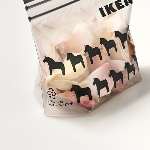 A transparent IKEA ISTAD bag with black horse designs, holding dried flowers, and reusable seal on top.