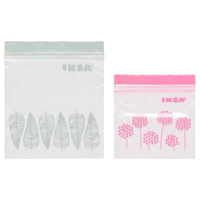 Two IKEA ISTAD resealable bags, one with green leaf designs, the other with pink floral patterns. Both are transparent with double seals.