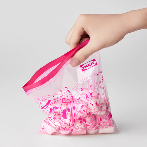 Hand holding reusable IKEA storage bag with map print, offering versatile kitchen organisation and preserved freshness.