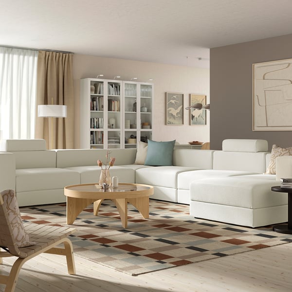 Modern living room with JÄTTEBO sofa, coffee table, bookshelf, rug, large window, and abstract art.