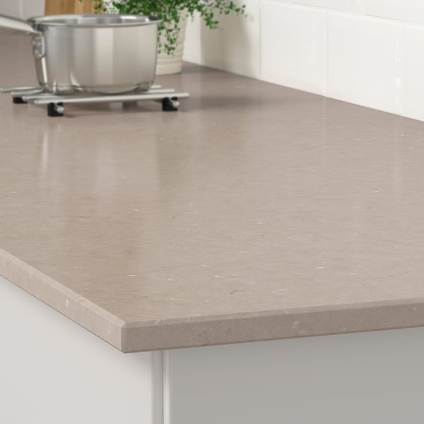 Modern kitchen countertop made of quartz, smooth and stain-resistant, with a custom edge design.