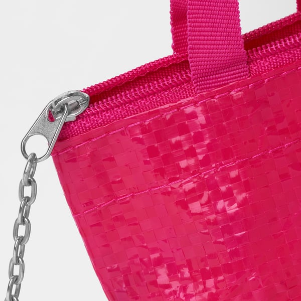 Bright pink woven bag with secure zip and attached silver chain keychain.