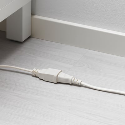 White electrical cord on floor, part of KOPPLA extension set.
