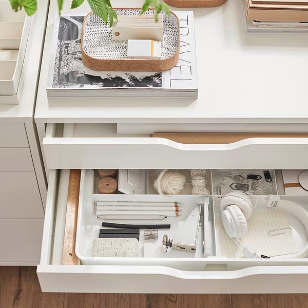 A white KUGGIS organiser drawer, divided into compartments for storing stationery and craft supplies.