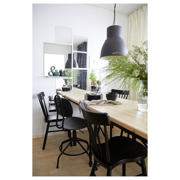 Modern dining area with wooden table, black chairs, and large pendant light.