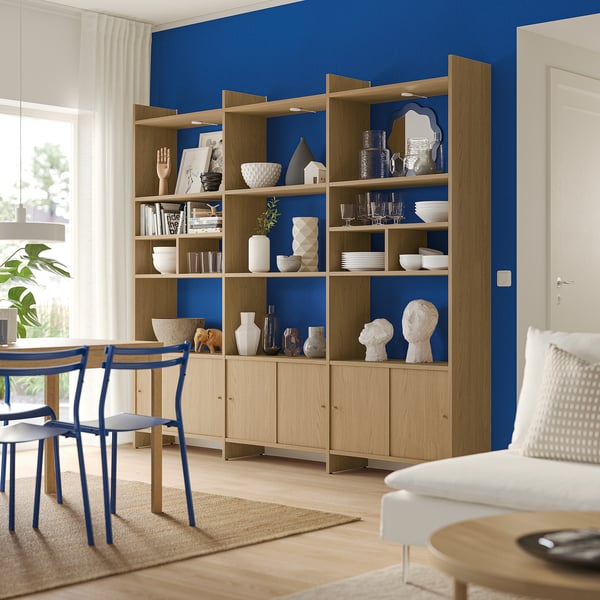 Modern room with wooden LÅDMAKARE shelving, blue accents, and white decor. Well-lit, combining functionality and style.