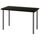 A LAGKAPTEN desk with a black top and metal legs. Its modern, rectangular, and sturdy with adjustable feet for stability.