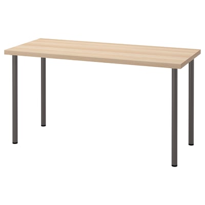 A wooden desk, LAGKAPTEN, with a light honeycomb top and black metal legs, standing on four adjustable feet for stability.