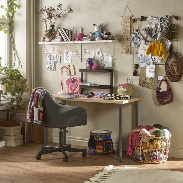 LAGKAPTEN craft desk with supplies, chair, and wall shelves.