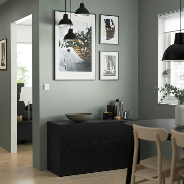 Modern room with LAPPVIKEN cabinet, three framed pictures, bowl, kettle, wooden chairs.