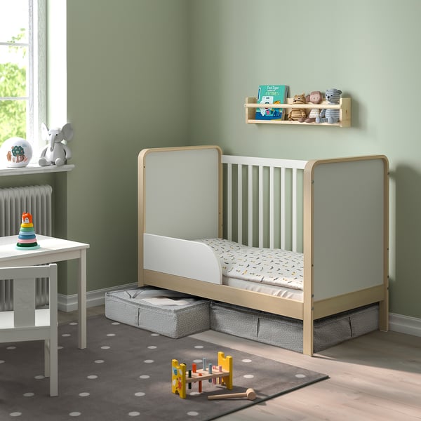 Kids room with fabric storage boxes under a wooden bed, polka-dot rug, and toys.