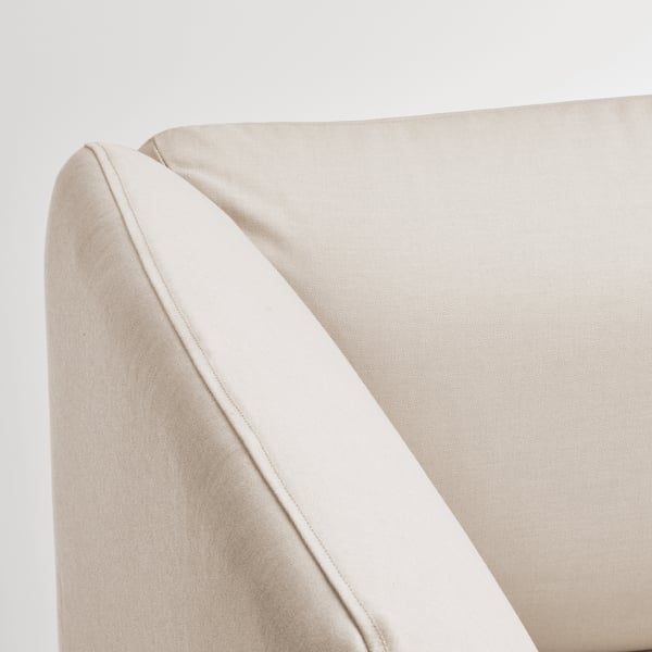 Sofa corner detail: smooth, beige fabric with clean stitching.