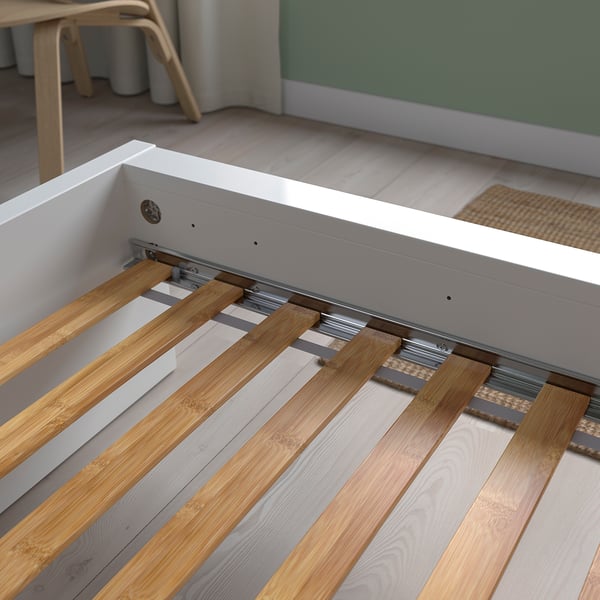A modern bed base with curved bamboo slats for durability and breathability. Metal rail guides for smooth mattress support.