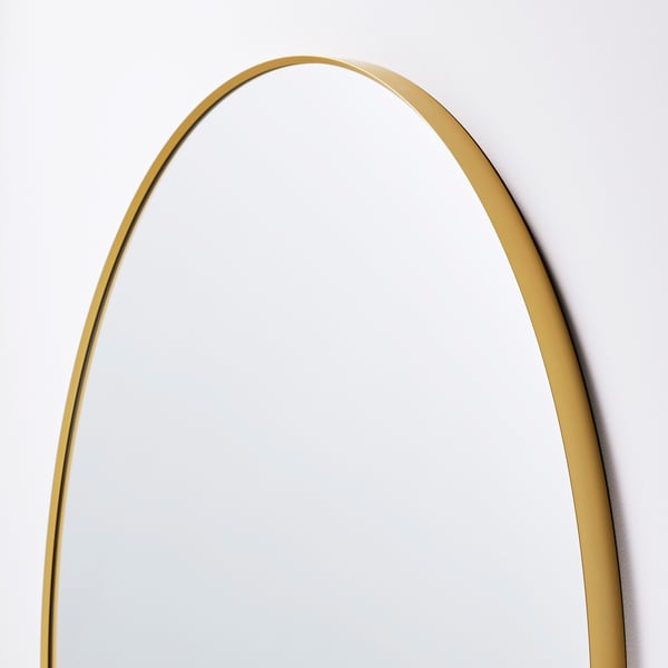 Golden-framed oval mirror, reflecting light, elegant and soft, adding depth to space.