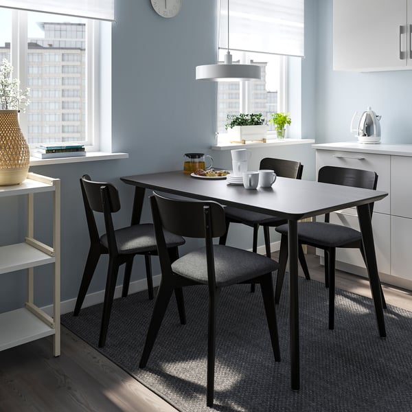 Modern dining set with rectangular black table and matching chairs. Bright and airy kitchen setting, ideal for small spaces.