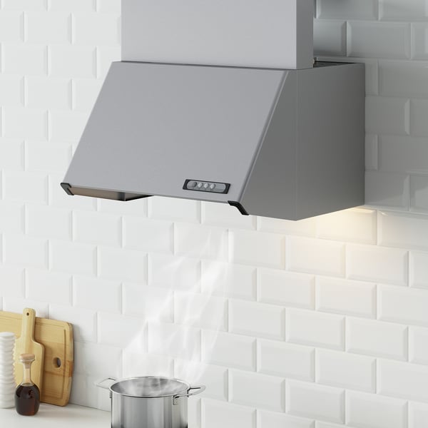 Silver LUFTIG kitchen hood, sleek, mounted above countertop on white brick wall.