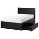 A modern, black wooden MALM bed in a minimalist style, featuring a high headboard and two large storage drawers on castors.