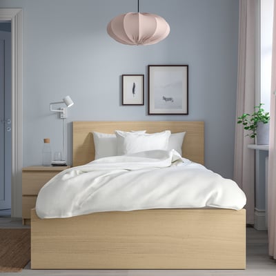 Modern bedroom with MALM bed, white linens, blue wall, pendant lamp, artwork, and small bedside table.
