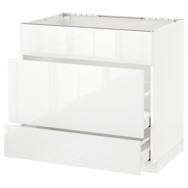 A modern, high-gloss white kitchen cabinet unit from the ikea METOD system. It multiple drawers and a sleek, contemporary design.