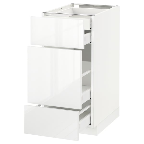 A white METOD kitchen cabinet with three open drawers. The cabinet is sleek and modern with glossy finish drawers.
