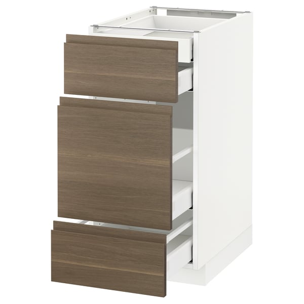 A white METOD kitchen cabinet with three dark walnut drawers, each featuring sleek, minimalist handles.