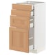 A white kitchen cabinet with wooden drawers and doors, featuring a modern design with smooth, light brown oak finish.