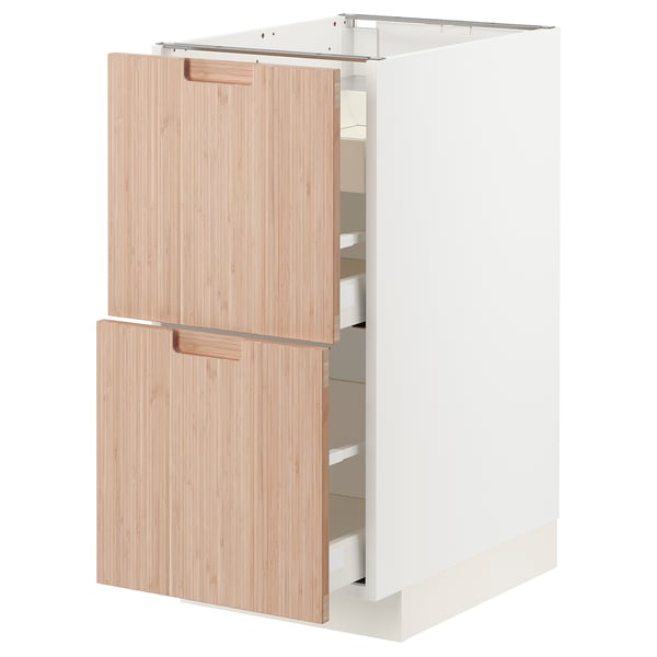 A white METOD kitchen cabinet with light bamboo drawers and doors.