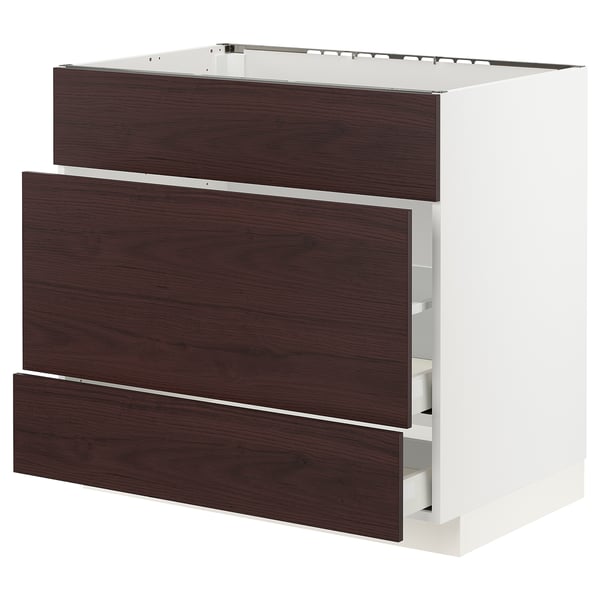 An ikea METOD kitchen cabinet in white with dark brown ash wood-patterned drawers.