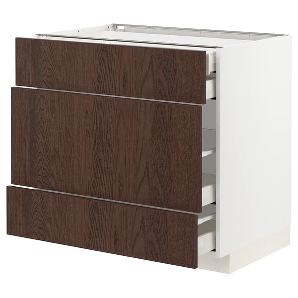 A modern kitchen cabinet named METOD with dark brown sinarp drawers featuring oak veneer and solid wood edging.