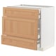 A white METOD kitchen cabinet with oak drawers, three partially open, showing organised compartments.